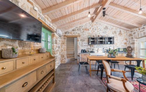 a kitchen and dining room with a table and a stone wall at Don Liri in Barat