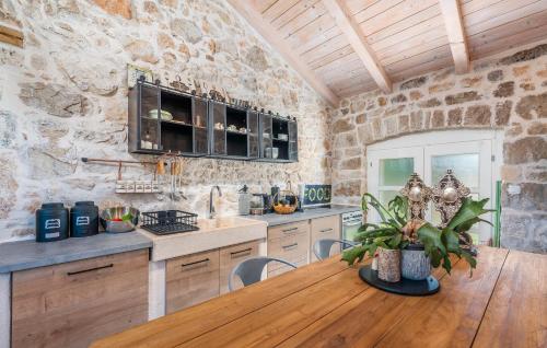 a kitchen with a wooden table and a stone wall at Don Liri in Barat