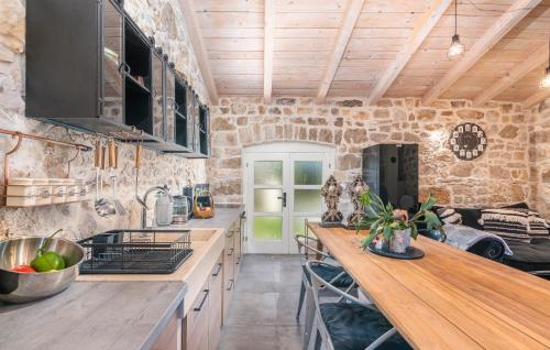 a kitchen with wooden ceilings and a stone wall at Don Liri in Barat