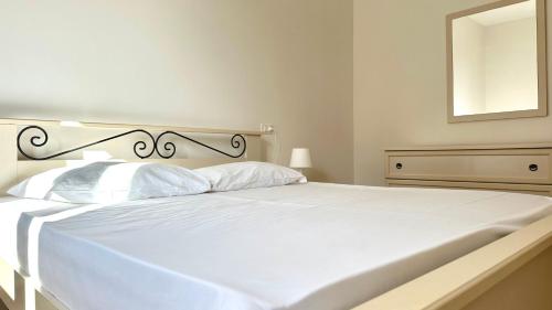 a white bed in a white bedroom with a mirror at N192 - Numana, nuova villetta con portico in Numana