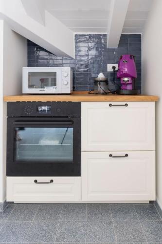 a kitchen with a stove and a microwave at Lara Maison in Acciaroli