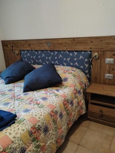 a bed with a quilt and a wooden head board at STOP & STARE STARS in Lignan