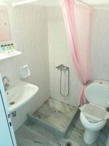 a bathroom with a shower and a toilet and a sink at Frangiscos in Parikia