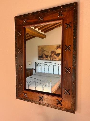 a mirror on a wall with a bed in it at LOCANDA PODERE LE VIGNE in Radda in Chianti