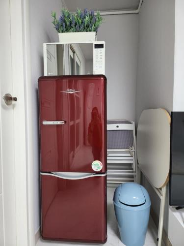 a red refrigerator in a room with a toilet at Clear Bridge House in Seoul