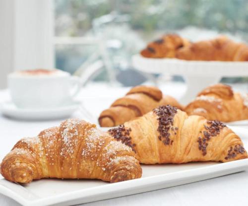 een bord croissants en andere zoete deegwaren op een tafel bij HOTEL HALF MOON RESTAURANT in Rimini