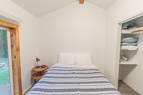 a bedroom with a bed with a blue and white striped bedspread at Lees Place in Neotsu