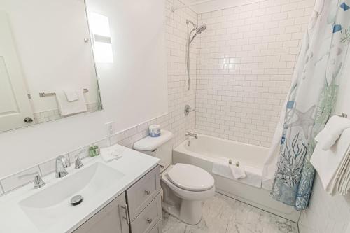 een witte badkamer met een toilet en een wastafel bij Lee's Place in Neotsu