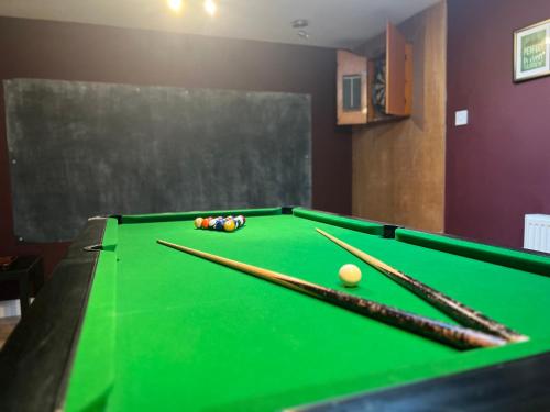 a pool table with cue balls and chopsticks on it at Charming Farm based cottage with hot tub and sauna in Newton