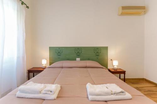 a bedroom with a large bed with two towels on it at NonnAdele in Iglesias