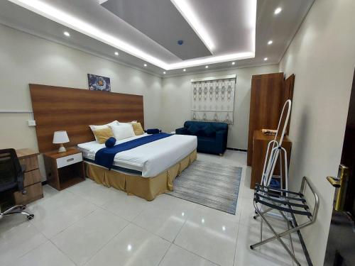 a bedroom with a bed and a desk and a chair at فندق منازل الضيف in Al Madinah