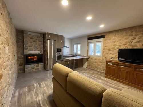 a living room with a couch and a kitchen at Casa Rural La Atalaya in Montarrón