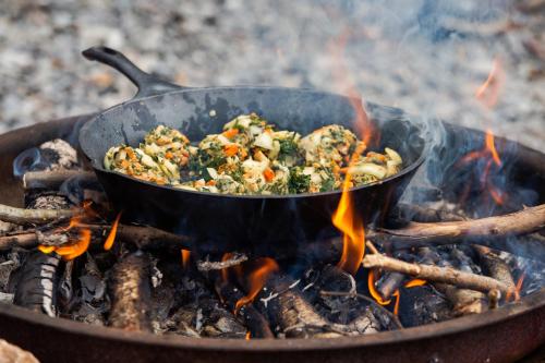 a pan of food cooking on top of a fire at TrekkingCamp Himmelsterrassen in Bad Peterstal-Griesbach