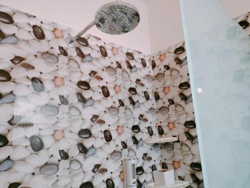 een badkamer met een muur bedekt met schelpen bij The Siyona Resort in Rāmnagar