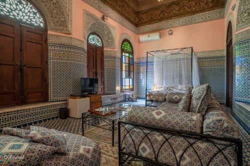 a living room with a couch and a tv at Riad Fes Palacete in Fez
