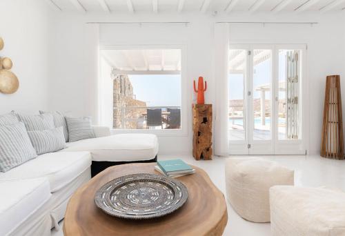 a living room with a white couch and a table at Villa Elia Breeze Mykonos in Mikonos