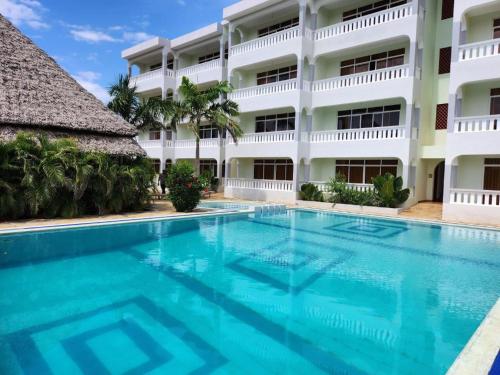 a swimming pool in front of a building at Nightingale Apartments Hotel Mombasa in Shanzu