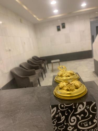 a room with a table with gold plates on it at لينا للوحدات السكنية المفروشة in Al Madinah