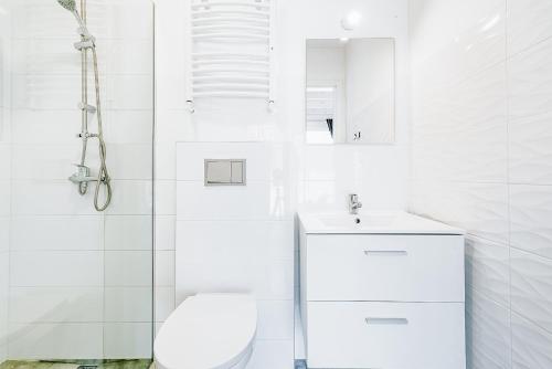 Baño blanco con aseo y lavamanos en Cichy Domek Apartamenty - Podgrzewany Basen en Karwia