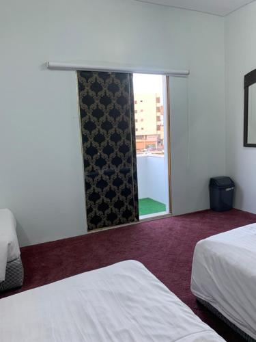 a hotel room with two beds and a window at لينا للوحدات السكنية المفروشة in Al Madinah