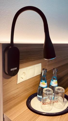 a light hanging over a plate with glasses on a table at GuestHouse Große Linde in Karlsruhe