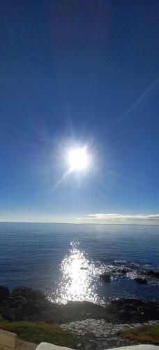 a sun shining over the ocean on a clear day at PlayaLasRicas in Las Eras