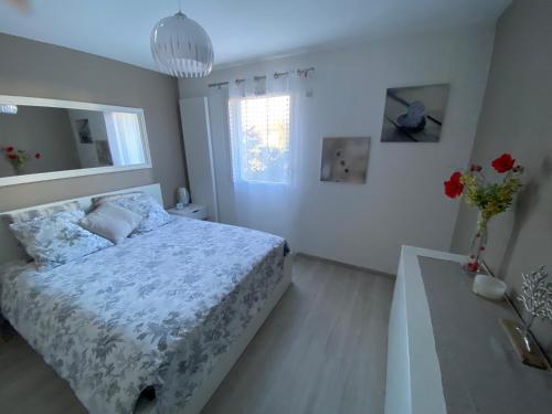 a bedroom with a bed and a vase of flowers at Appartement neuf au calme proche du lac in Saint-Jorioz