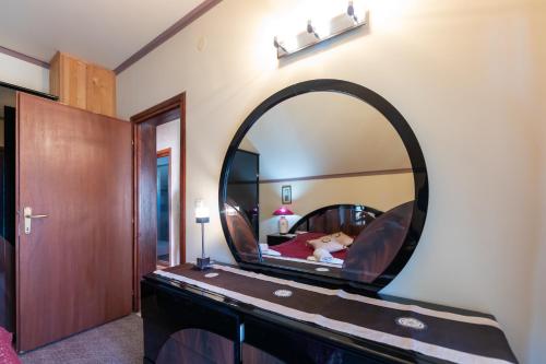 a bedroom with a large mirror on the wall at Vikendica Životić in Zlatibor