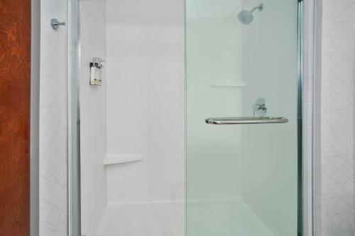 a bathroom with two white shower doors and a mirror at Holiday Inn Express Hotel & Suites - Belleville Area by IHG in Belleville