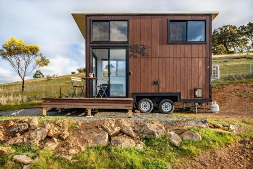 une petite maison sur une remorque avec un banc dans l'établissement Montara Views 3, à Ararat