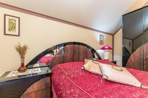 a bedroom with two beds with red sheets at Vikendica Životić in Zlatibor