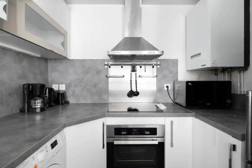 a kitchen with white cabinets and a stove top oven at 123paris city in Paris