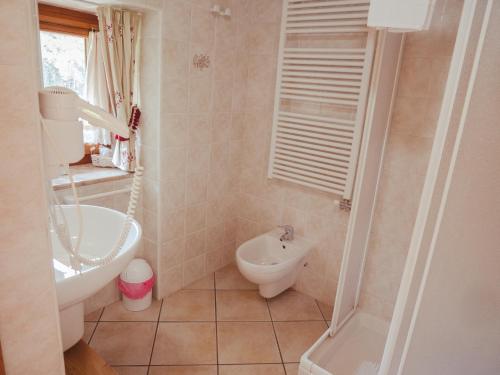 a bathroom with a sink and a toilet and a tub at La Majon de Fohten in Montjovet