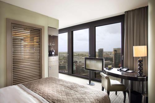 a bedroom with a bed and a desk with a computer at Hyatt Regency Dusseldorf in Düsseldorf