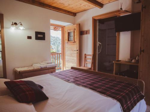a bedroom with a bed and a balcony at La Majon de Fohten in Montjovet
