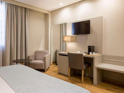 Cette chambre comprend un lit, un bureau et une chaise. dans l'établissement Mercure Carlton Rioja, à Logroño