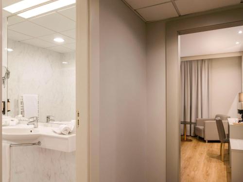 La salle de bains est pourvue d'un lavabo et d'un miroir. dans l'établissement Mercure Carlton Rioja, à Logroño