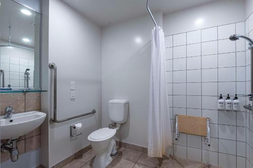 a bathroom with a toilet and a sink and a shower at Quality Hotel Oceans Tutukaka in Tutukaka