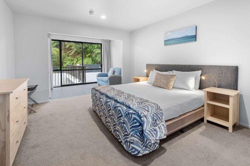 a bedroom with a bed and a desk and a window at Quality Hotel Oceans Tutukaka in Tutukaka