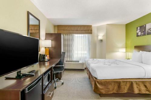 a hotel room with a bed and a flat screen tv at Sleep Inn in Hickory