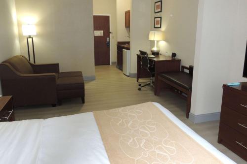 a hotel room with a bed and a living room at Comfort Suites in Twinsburg