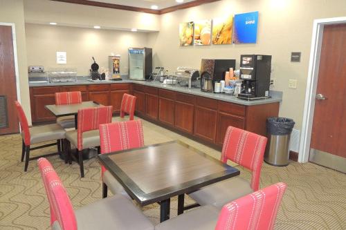 a restaurant with a table and chairs and a counter at Comfort Suites in Twinsburg