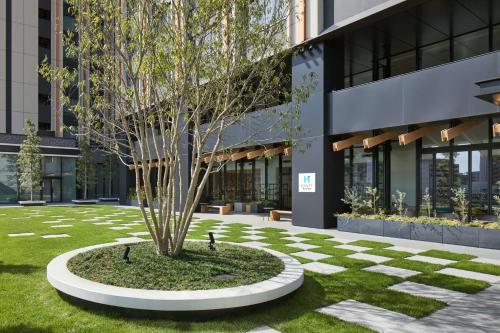 a tree in a circle in front of a building at Hyatt House Kanazawa in Kanazawa