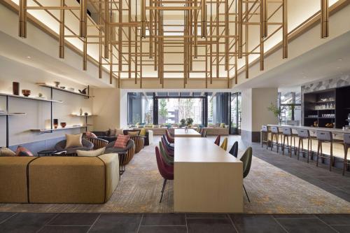 a lobby with couches and a table and chairs at Hyatt House Kanazawa in Kanazawa