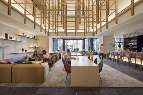 a lobby with people sitting on couches and tables at Hyatt House Kanazawa in Kanazawa