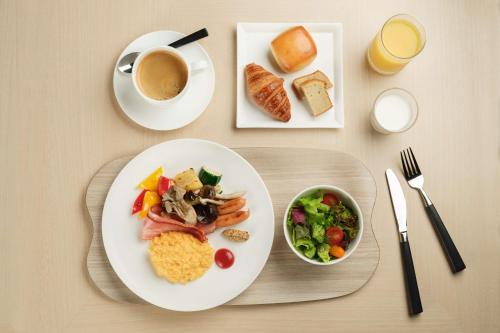 a table with a plate of food and a cup of coffee at Hyatt House Kanazawa in Kanazawa