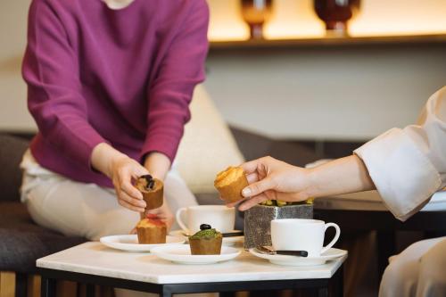 a group of people eating food on a coffee table at Hyatt House Kanazawa in Kanazawa