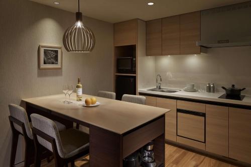 a kitchen with a island with a table and chairs at Hyatt House Kanazawa in Kanazawa