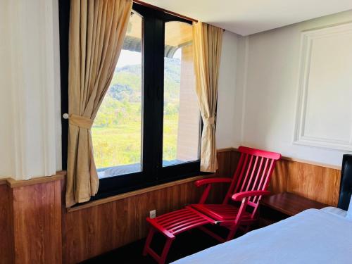 2 sillas rojas en un dormitorio con ventana en Homestay Thác Liên Khương, en Ðưc Trọng