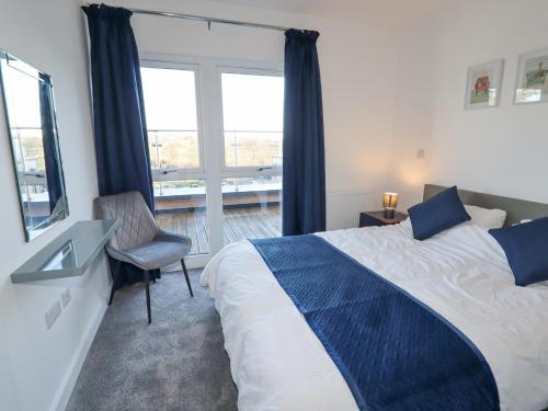 1 dormitorio con cama, ventana y silla en 22 River View en Preston